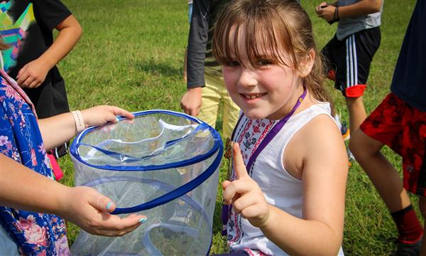 Girl holds out butterfly